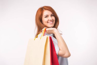 Beyaz arka plan üzerinde alışveriş torbaları mutlu kızıl saçlı Bayan portresi