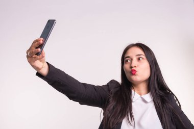 Genç Asyalı kadın beyaz arka plan üzerinde Studio selfie yapma