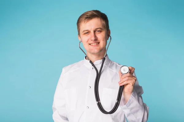 Χαμογελαστός άνθρωπος ιατρός με στηθοσκόπιο σε μπλε φόντο με αντίγραφο χώρου — Φωτογραφία Αρχείου