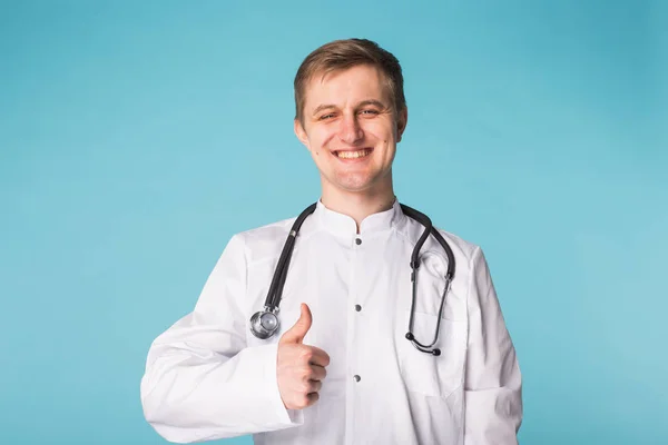 의료 의사 의사 남자 엄지손가락 파란색 배경 위에 표시 — 스톡 사진