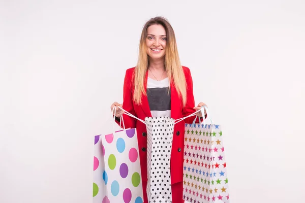 Retrato de una joven rubia pecosa con bolsas de compras sobre fondo blanco — Foto de Stock