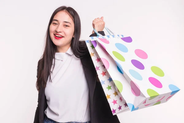 Retrato de joven morena feliz con bolsas de compras sobre fondo blanco — Foto de Stock