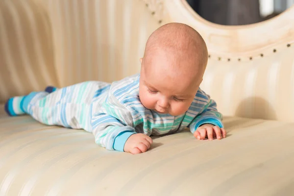 Adorable bebé en el dormitorio soleado. Niño recién nacido relajándose —  Fotos de Stock