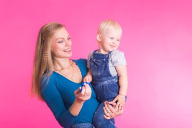 mutlu küçük kız ve annesi pembe arka plan üzerinde eğleniyor