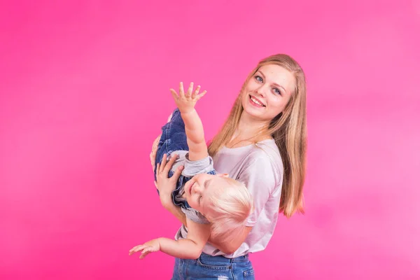 Мати і дочка розважаються ізольовані на рожевому фоні — стокове фото