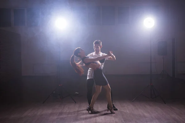 Молодая пара танцует латинский танец бачата, меренге, сальса. Две элегантные позы в танцевальном классе — стоковое фото
