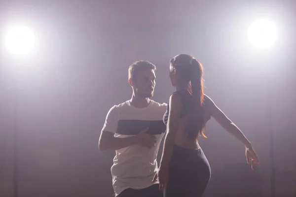 Bailarines hábiles actuando en la sala oscura bajo la luz del concierto y el humo. Pareja sensual realizando una danza contemporánea artística y emocional — Foto de Stock