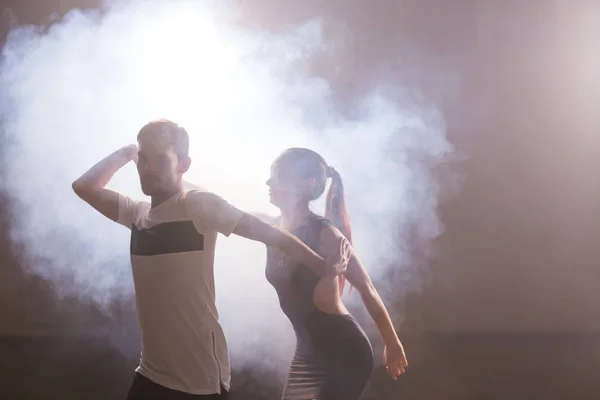 Pareja joven bailando baile latino Bachata, merengue, salsa. Dos poses de elegancia en clase de baile — Foto de Stock