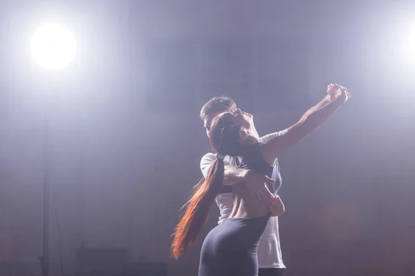 Pareja joven bailando baile latino Bachata, merengue, salsa. Dos poses de elegancia en clase de baile — Foto de Stock