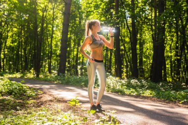 Açık havada koşu sonra genç kadın içme suyu