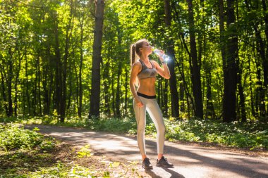 Açık havada çalıştırdıktan sonra genç kadın içme suyu