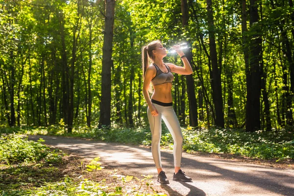 Açık havada koşu sonra genç kadın içme suyu