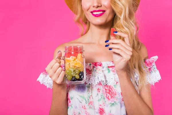 Pembe bir arka plan üzerinde yeşil güler yüzlü genç güzel kadın.