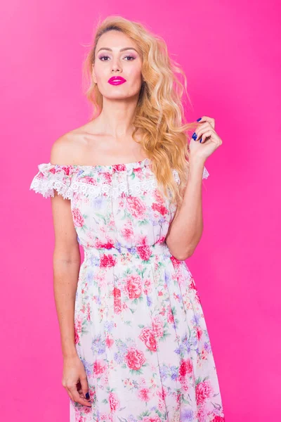 Menina bonita vestindo vestido posando no fundo rosa no estúdio. Verão, feriados e conceito de moda — Fotografia de Stock