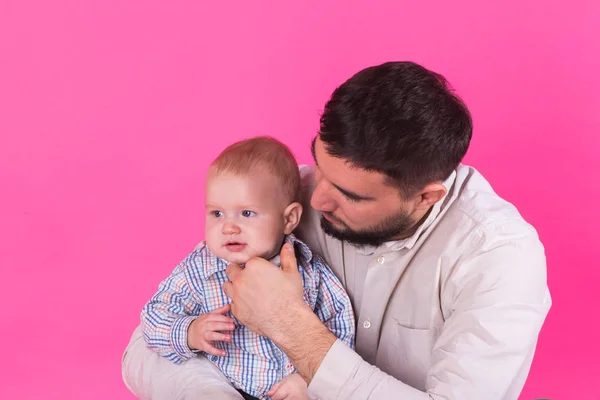 Bebé en las manos de papá. Fondo rosa . — Foto de Stock