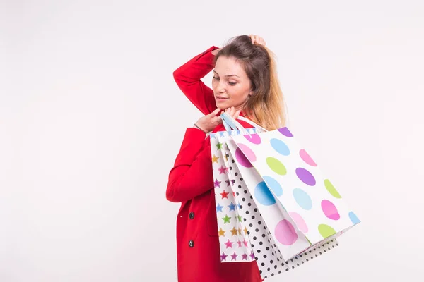 Retrato de mujer hermosa en chaqueta roja con bolsas de compras en la espalda con espacio para copiar . — Foto de Stock