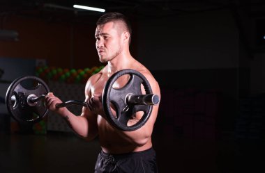 kas genç adam koyu arka plan üzerinde ağırlık kaldırma