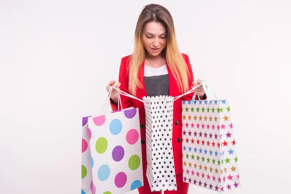 Retrato de mujer sorprendida en traje rojo con bolsas de compras . — Foto de Stock