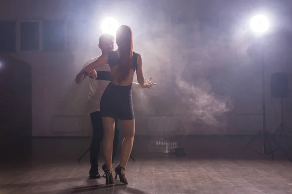 Pareja joven bailando baile latino Bachata, merengue, salsa. Dos poses de elegancia en clase de baile — Foto de Stock