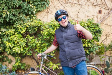 Başparmak parkta güneşli günde gösterilmesini bisiklet ile yakışıklı genç