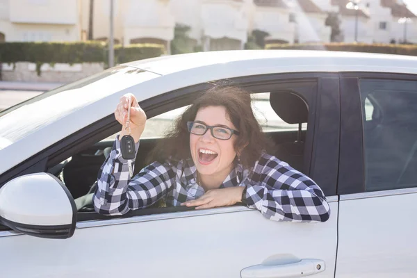 Mladá šťastná žena ukazující klíč nové auto — Stock fotografie