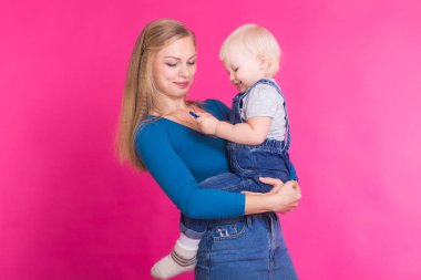 genç anne ve kızı birlikte eğleniyor arka plan pembe