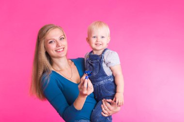 Anne ve kızı, pembe arka plan izole eğleniyor