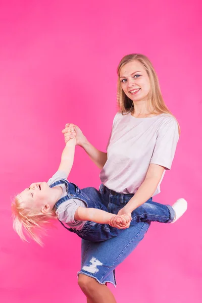 Felice bambina e sua madre divertirsi su sfondo rosa — Foto Stock