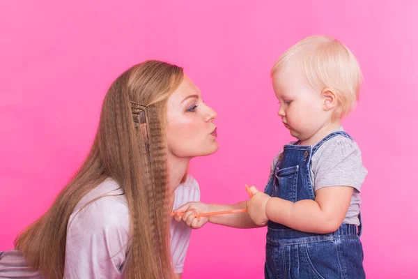 Funny family on pink background. Mother and her daughter girl. Mom and child are having fun. — Stock Photo, Image