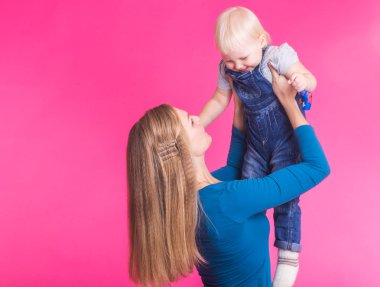 genç anne ve kızı birlikte eğleniyor arka plan pembe