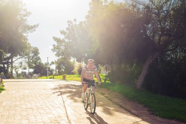Güneşli bir günde bisiklet sürerken formda olan genç adam..