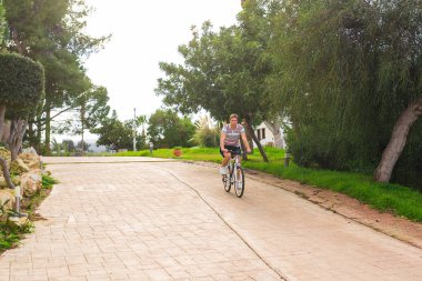 Güneşli bir günde bisiklet sürerken formda olan genç adam..