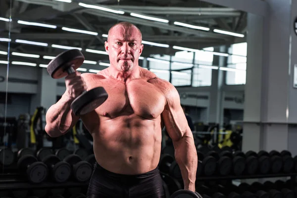 Guapo culturista hombre con grandes músculos en el gimnasio — Foto de Stock