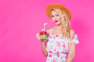 Boşaltmak pembe zemin üzerine yeşil güler yüzlü genç güzel kadın