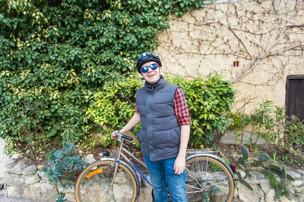 Divertente ciclista estate in sella a un ragazzo su una bicicletta da giardino in un casco — Foto Stock