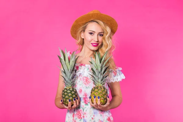 Szczęśliwa młoda kobieta trzyma ananasa na różowym tle. Koncepcja lato, dieta i święta — Zdjęcie stockowe