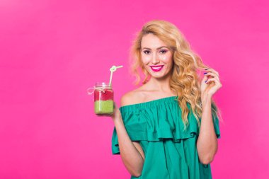 Boşaltmak pembe zemin üzerine yeşil güler yüzlü genç güzel kadın