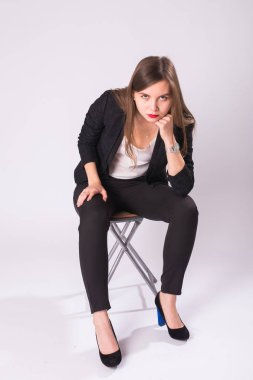 bir sandalye beyaz arka planda siyah elbiseli güzel genç iş kadını oturur