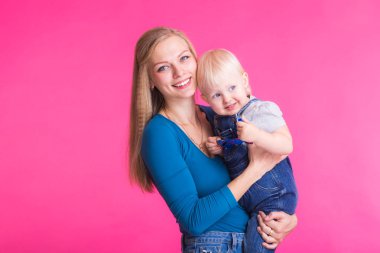 genç anne ve kızı birlikte eğleniyor arka plan pembe