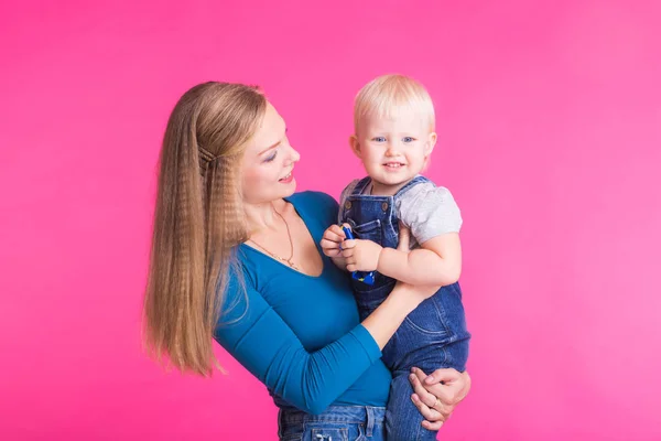 Anne ve kızı, pembe arka plan izole eğleniyor — Stok fotoğraf