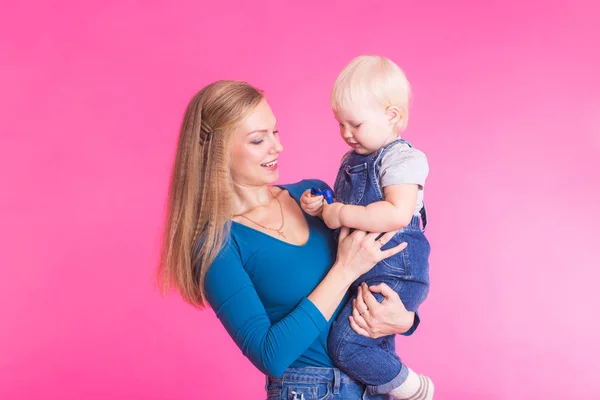 Joven madre e hija divirtiéndose juntas sobre fondo rosa — Foto de Stock