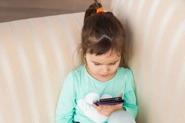 Küçük kız ile oda içinde smartphone — Stok fotoğraf