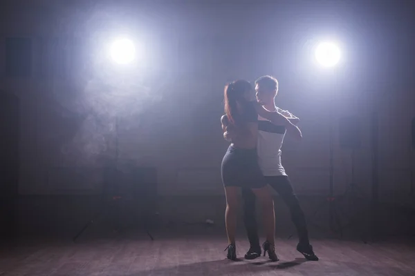 Jeune couple dansant danse latine Bachata, merengue, salsa. Deux poses d'élégance en cours de danse — Photo