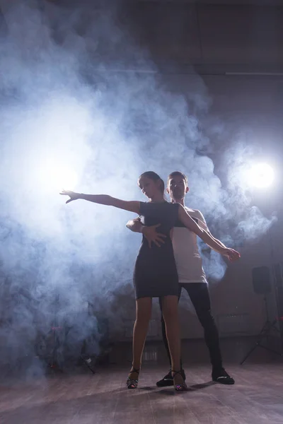 Pareja joven bailando baile latino Bachata, merengue, salsa. Dos poses de elegancia en clase de baile — Foto de Stock