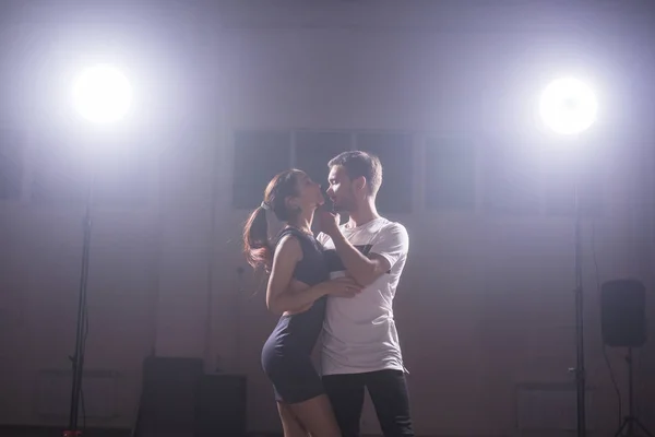 Dançarinos habilidosos se apresentando na sala escura sob a luz do concerto e fumaça. Casal sensual realizando uma dança contemporânea artística e emocional — Fotografia de Stock