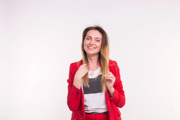 Portrait of young woman in a red suit posing on white background with copy space — Stock Photo, Image