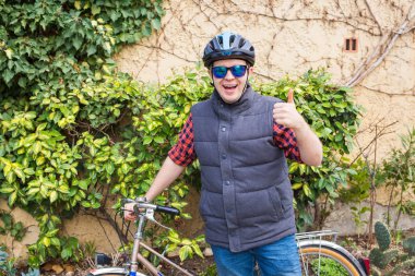 Başparmak parkta güneşli günde gösterilmesini bisiklet ile yakışıklı genç