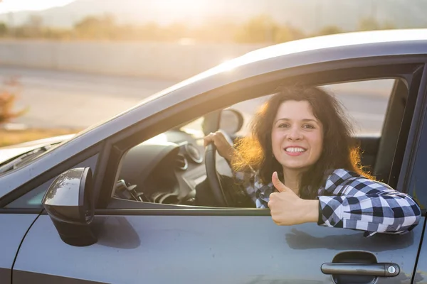 Glückliche Frau zeigt Daumen hoch und fährt ein neues Auto — Stockfoto