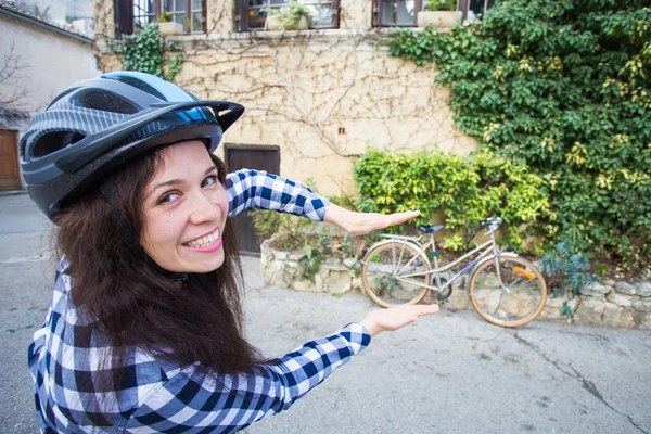 헬멧 자전거 및 골목 배경에 포즈 젊은 재미 있는 여자 — 스톡 사진