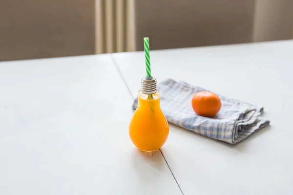 Апельсиновый сок в интересном стакане на столе — стоковое фото